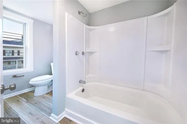 a bathroom with a toilet and a bathtub