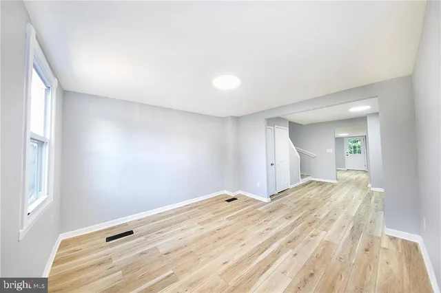 a view of empty room with wooden floor
