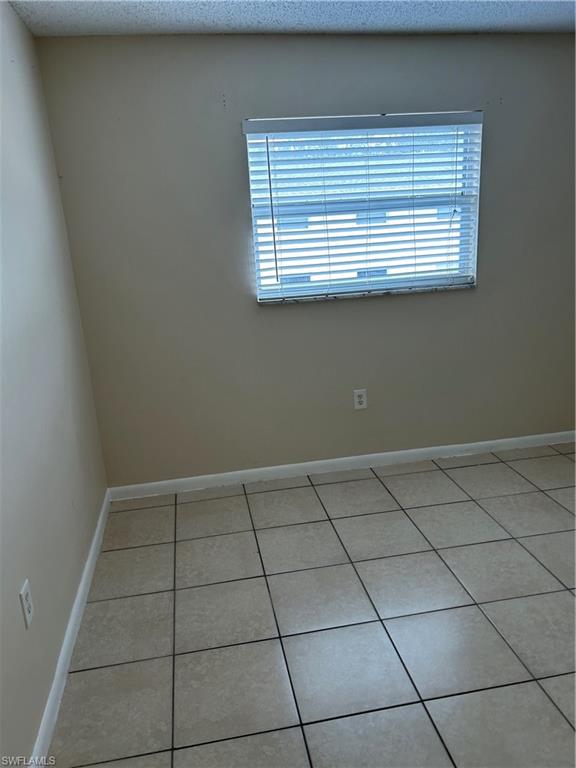 3325 Airport-Pulling Road Naples, FL 34105 - Photo 5 of 9 Unfurnished room with light tile patterned floors and a textured ceiling