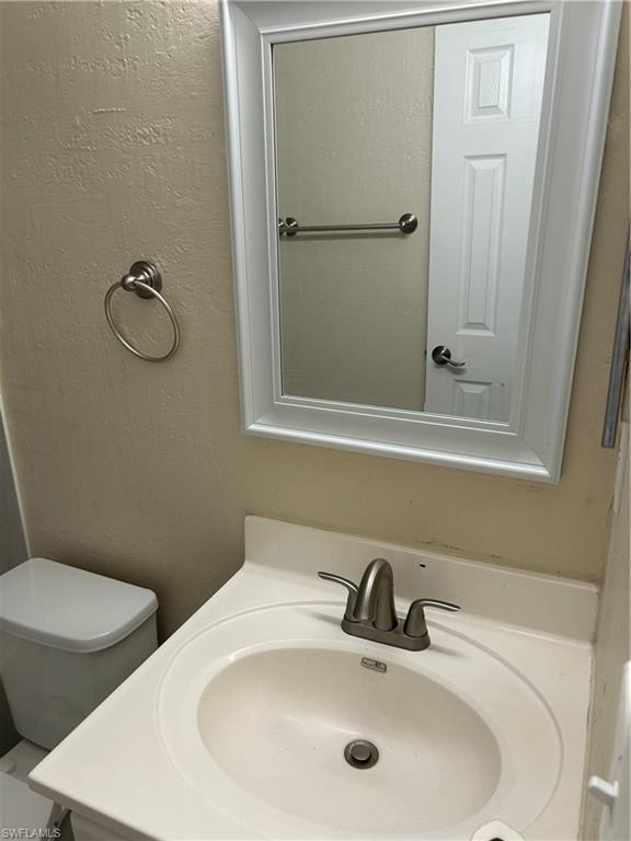 3325 Airport-Pulling Road Naples, FL 34105 - Photo 6 of 9 Bathroom featuring vanity and a textured wall