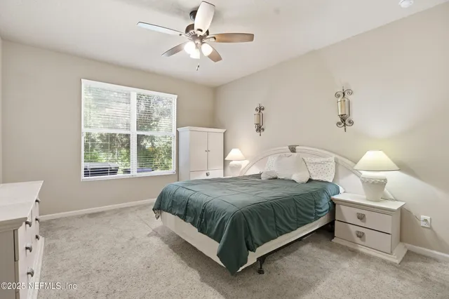 a bedroom with a bed chandelier and a window