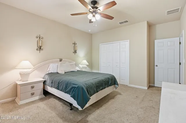 a bedroom with a bed and a ceiling fan