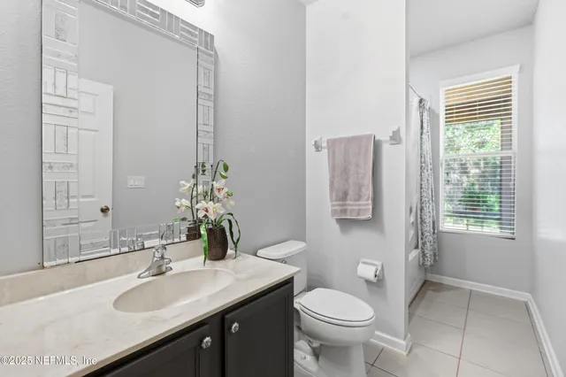a bathroom with a granite countertop toilet a sink and a mirror