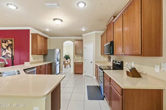 a kitchen with stainless steel appliances a sink a stove and a refrigerator