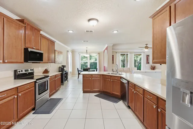 a large kitchen with stainless steel appliances granite countertop a large stove top oven a sink dishwasher and a refrigerator