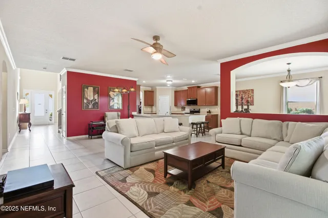 a living room with furniture kitchen view and a chandelier
