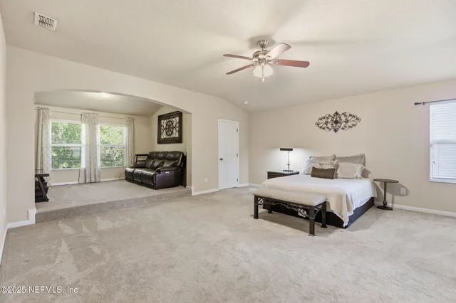 a spacious bedroom with a bed and a chandelier
