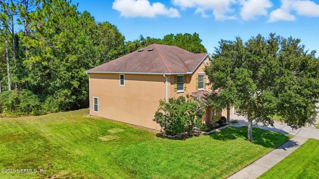 a aerial view of a house next to a yard