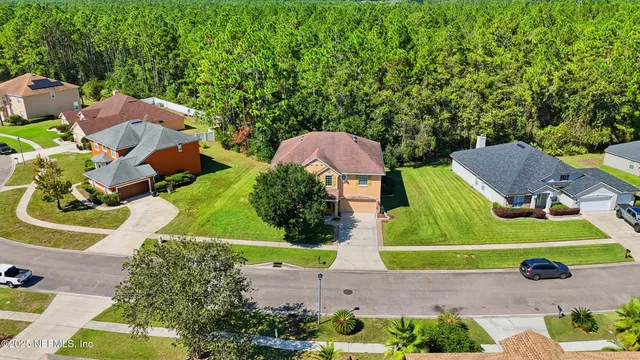 an aerial view of a house with a yard and lake view
