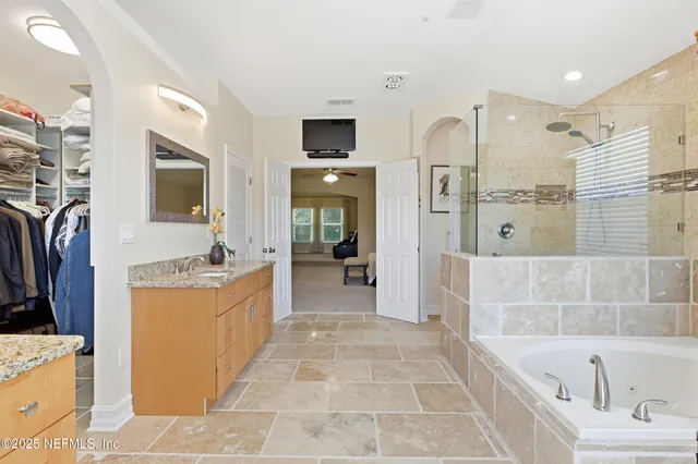 a bathroom with a tub sink and mirror