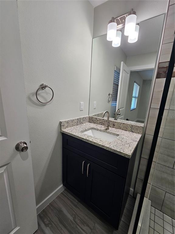7043 Brentford Road Sarasota, FL 34241 - Photo 11 of 19 a bathroom with a granite countertop sink a light fixture and a mirror