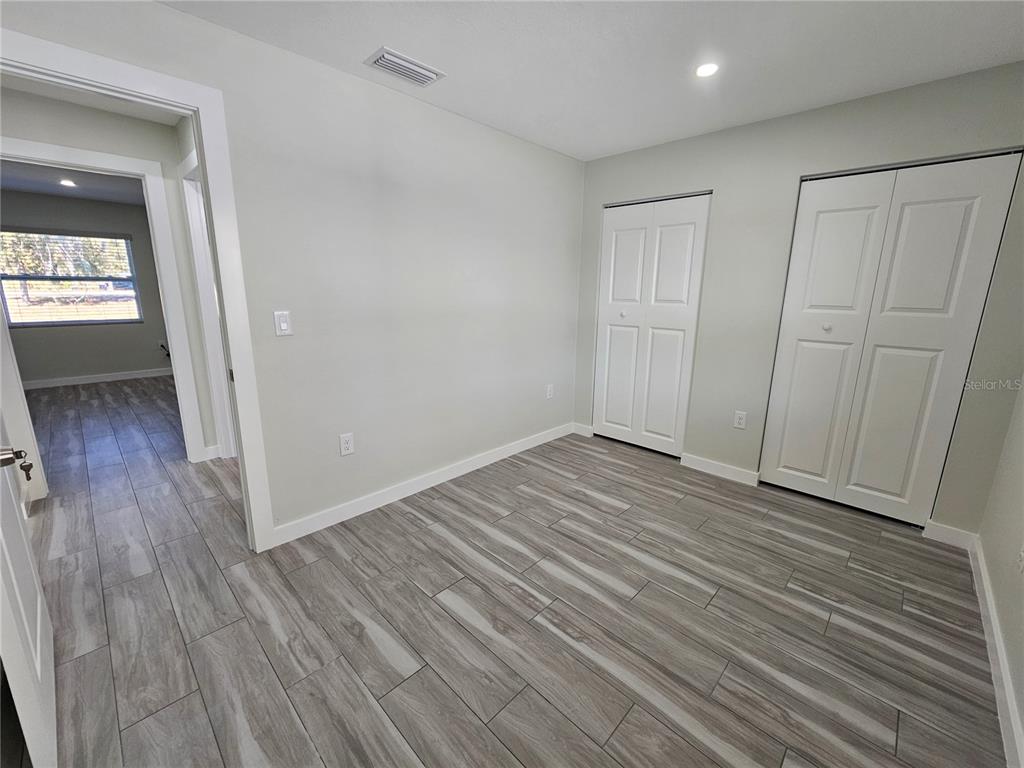 7043 Brentford Road Sarasota, FL 34241 - Photo 14 of 19 wooden floor in an empty room with a window