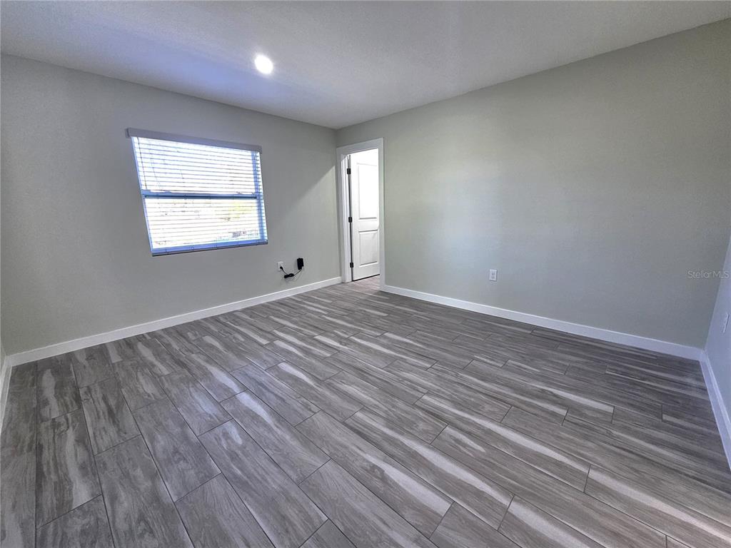 7043 Brentford Road Sarasota, FL 34241 - Photo 9 of 19 wooden floor in an empty room with a window