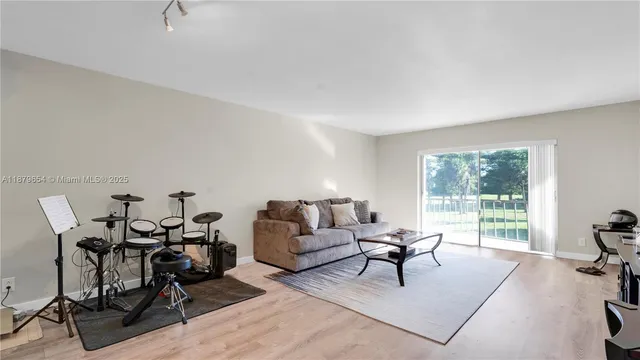 a living room with furniture a table and a floor to ceiling window