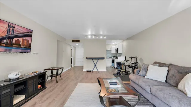 a living room with furniture a wooden floor and a chandelier