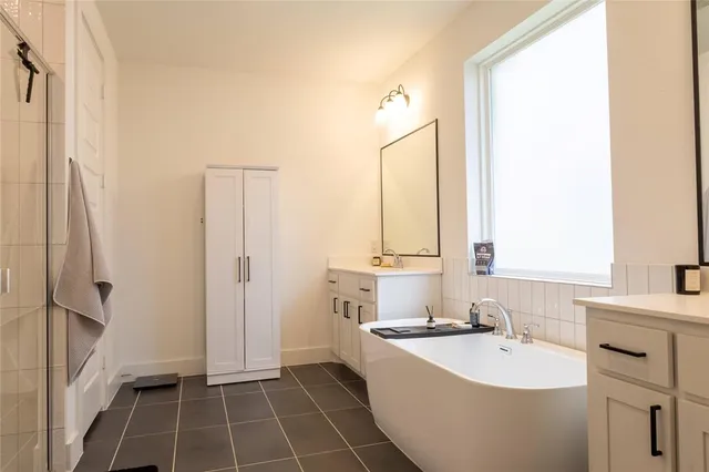 a bathroom with a tub sink and mirror