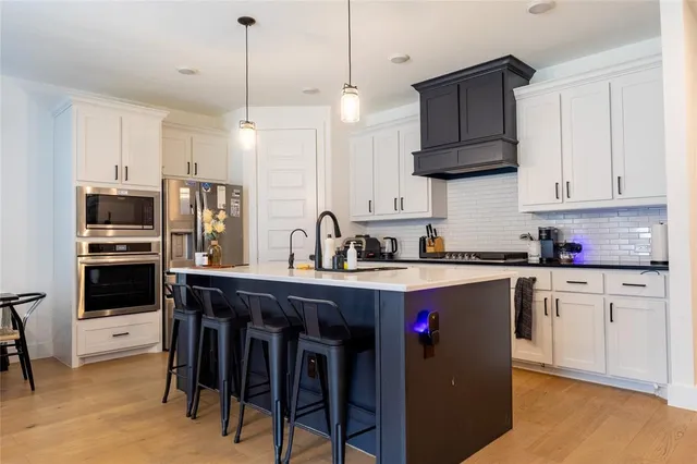 a kitchen with stainless steel appliances granite countertop a sink a stove a refrigerator and cabinets