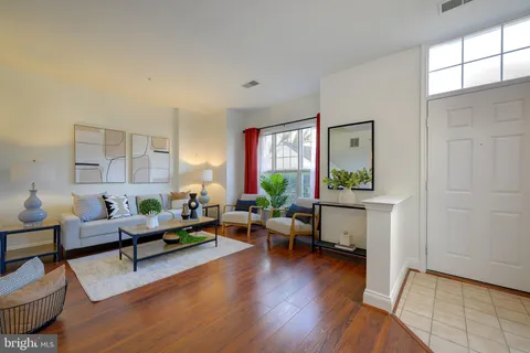 a living room with furniture and a wooden floor