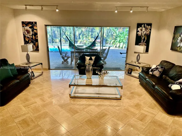 a living room with furniture large window and floor to ceiling window