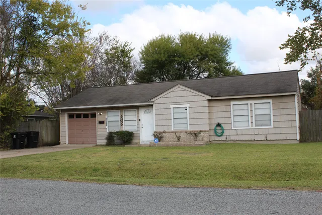 a front view of a house with a yard and trees
