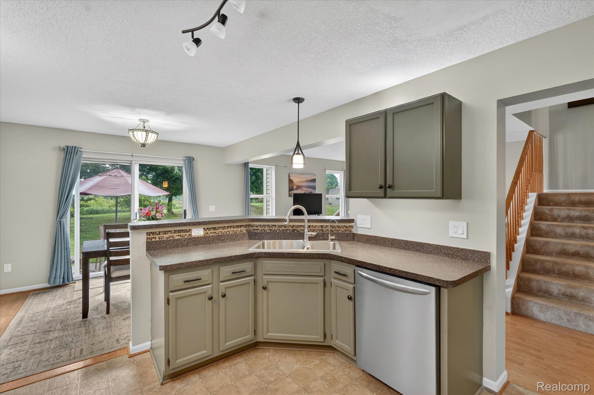 456 Lilly View Court Howell, MI 48843 - Photo 8 of 45 Kitchen featuring a corner stainless steel sink, integrated dishwasher, and upper and lower cabinetry