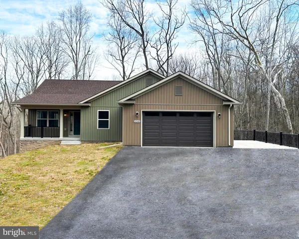 a front view of a house with yard and trees