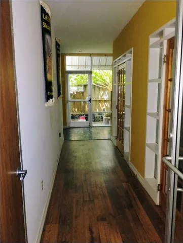 a view of a hallway with wooden floor and dining room