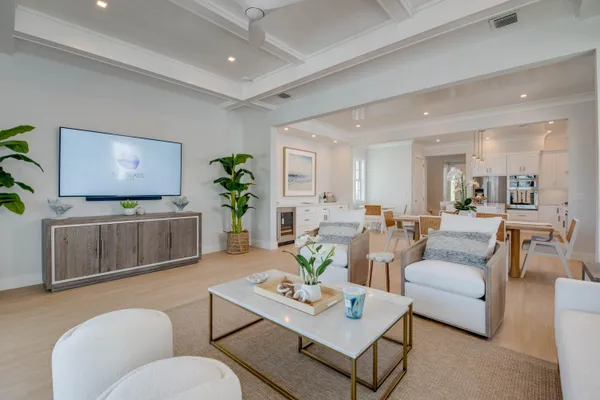 a living room with furniture a flat screen tv and kitchen view