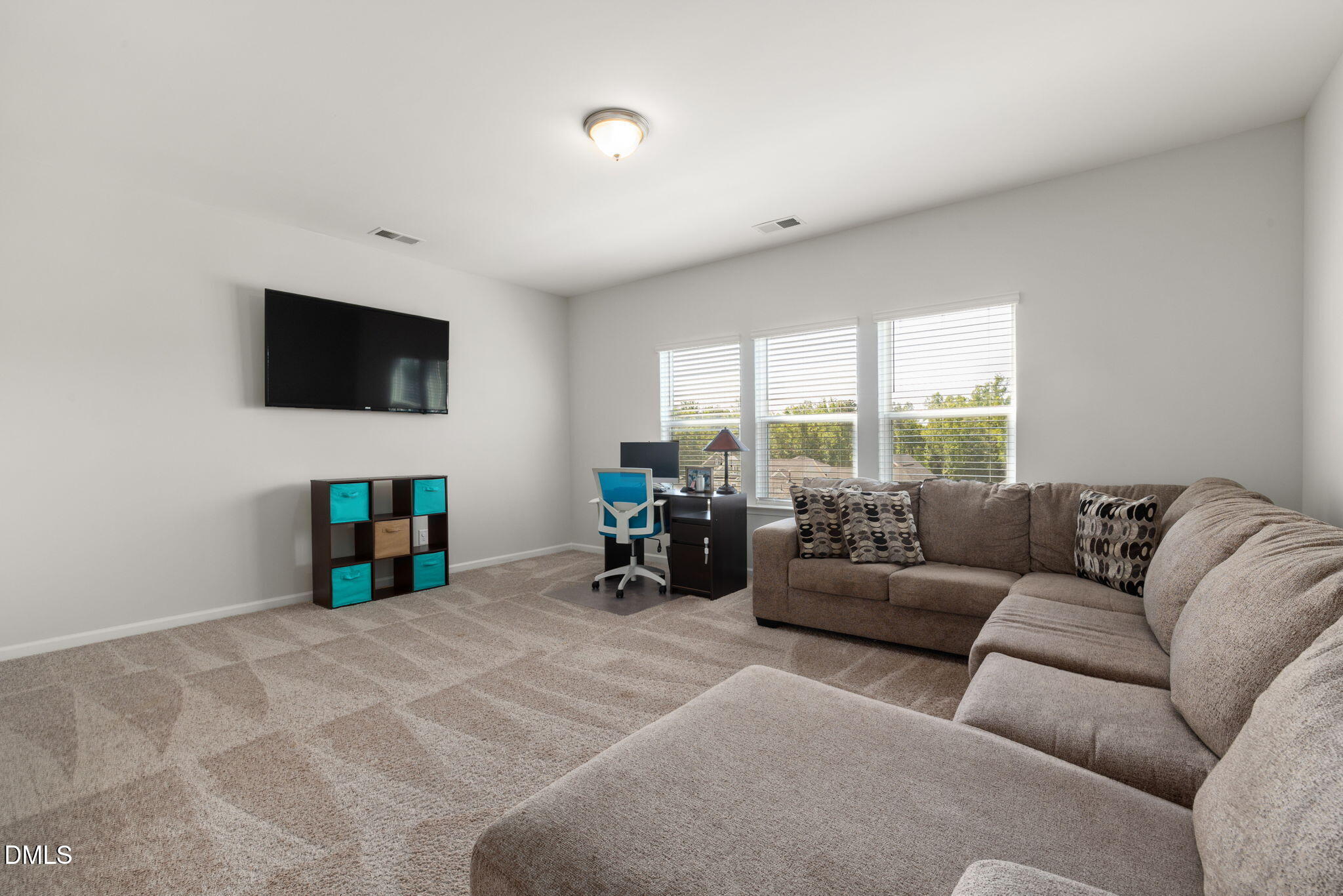 3422 Longleaf Estates Drive Raleigh, NC 27616 - Photo 29 of 71 a living room with furniture a flat screen tv and a floor to ceiling window