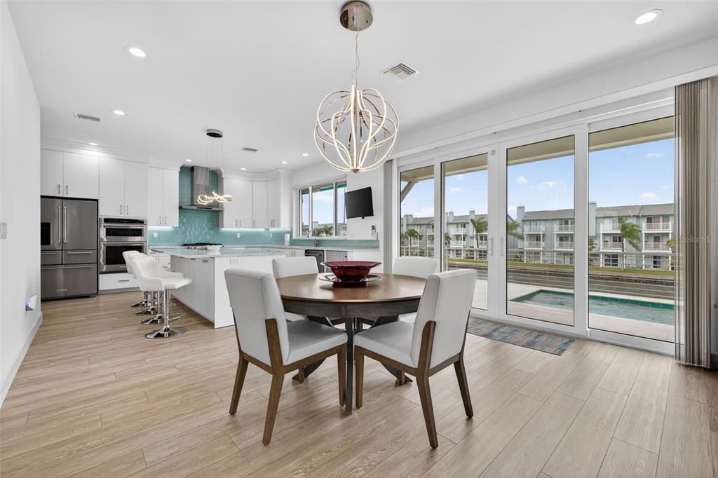 314 6th Avenue Indian Rocks Beach, FL 33785 - Photo 12 of 60 a dining room with furniture a chandelier and wooden floor