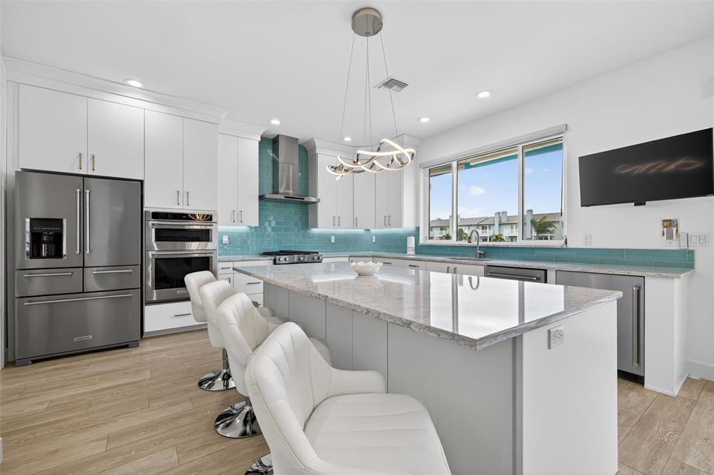 314 6th Avenue Indian Rocks Beach, FL 33785 - Photo 14 of 60 a kitchen with kitchen island stainless steel appliances a sink and refrigerator