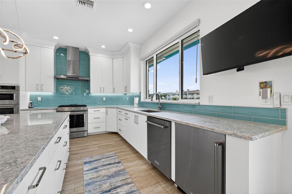 314 6th Avenue Indian Rocks Beach, FL 33785 - Photo 15 of 60 a large kitchen with stainless steel appliances granite countertop a sink and a stove