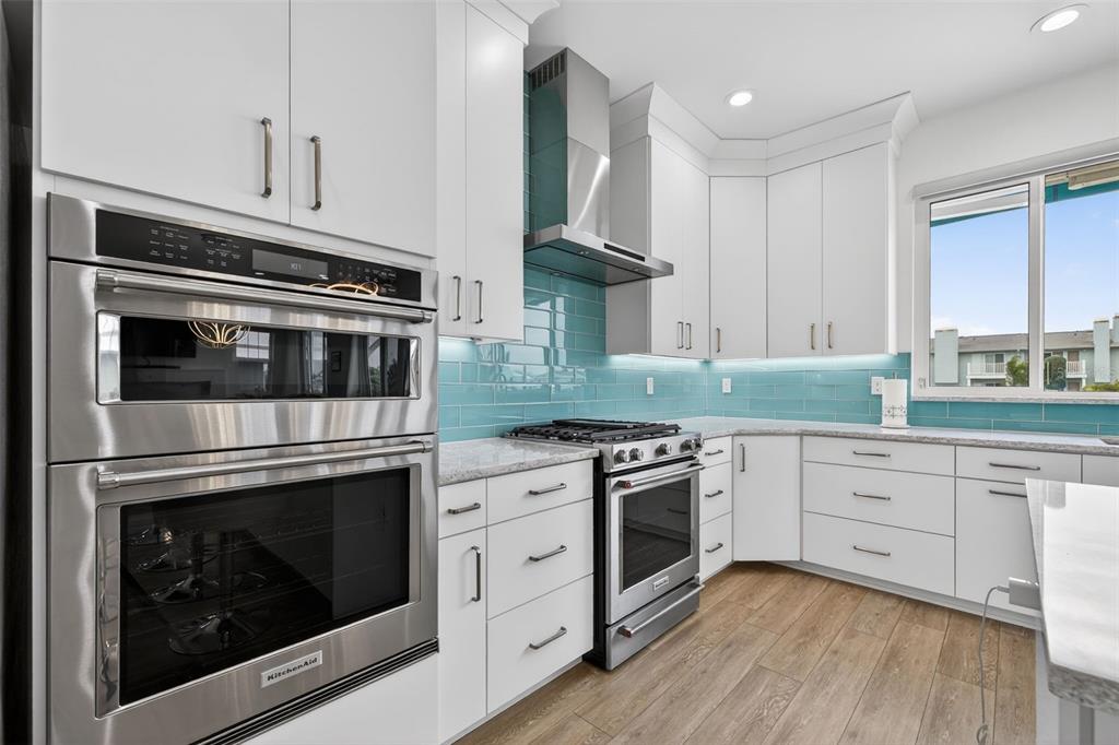 314 6th Avenue Indian Rocks Beach, FL 33785 - Photo 19 of 60 a kitchen with cabinets stainless steel appliances and wooden floor