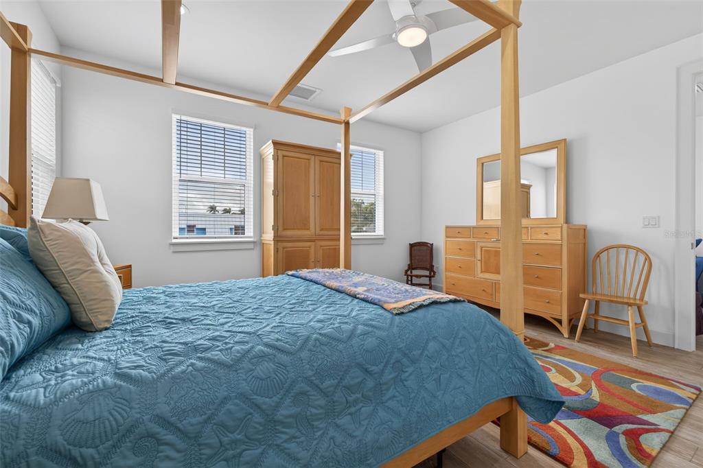314 6th Avenue Indian Rocks Beach, FL 33785 - Photo 29 of 60 a bedroom with a bed chairs and wooden floor
