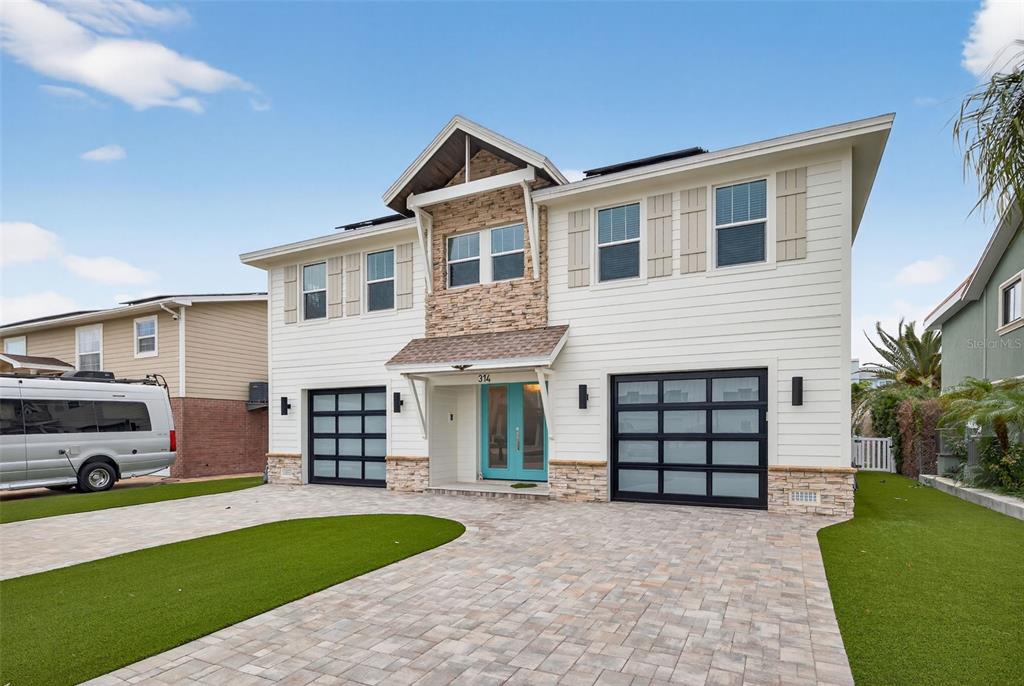 314 6th Avenue Indian Rocks Beach, FL 33785 - Photo 6 of 60 a front view of a house with a yard and garage