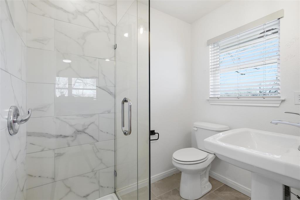 301 West Tinsley Road Robinson, TX 76706 - Photo 26 of 40 a bathroom with a toilet sink vanity and shower