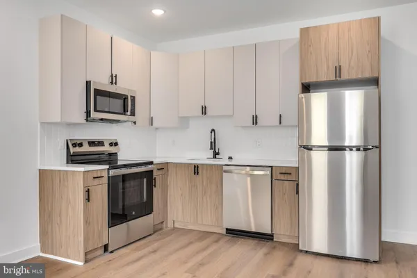 a kitchen with stainless steel appliances granite countertop a refrigerator stove a sink and a microwave