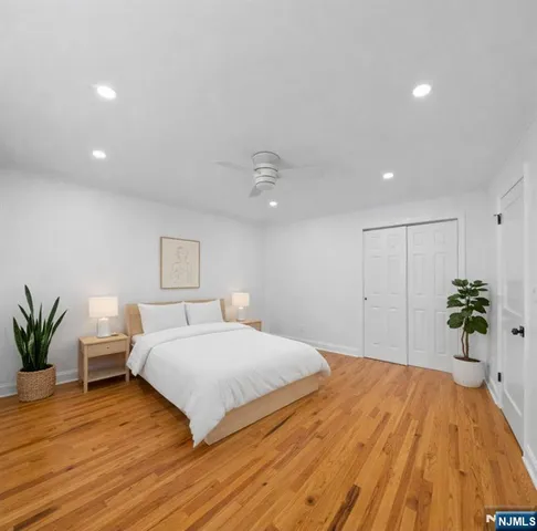a bedroom with a large bed and a potted plant