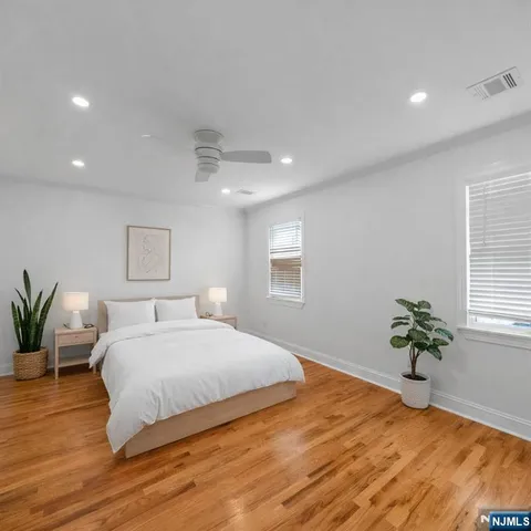 a bedroom with a large bed and a potted plant