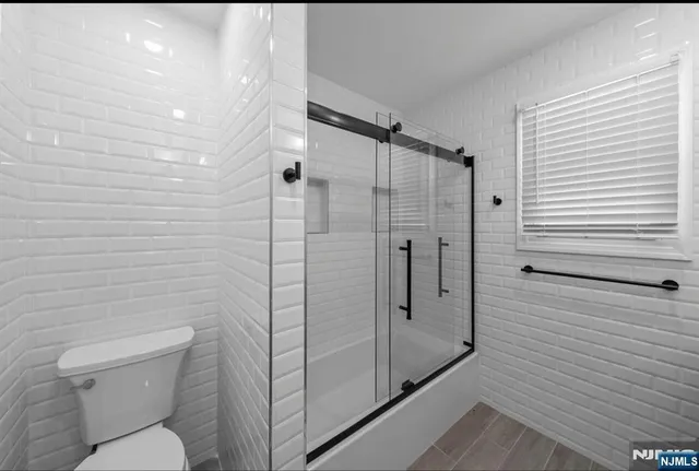 a kitchen with stainless steel appliances granite countertop a refrigerator a stove top oven a sink dishwasher and white cabinets with wooden floor