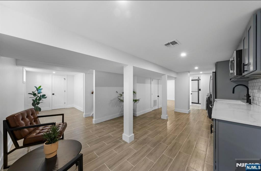 301 New Bridge Road Bergenfield, NJ 07621 - Photo 18 of 27 a living room with furniture and a wooden floor