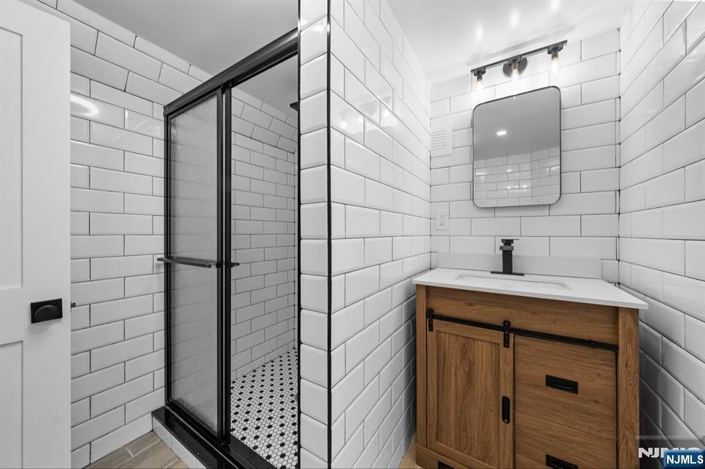 301 New Bridge Road Bergenfield, NJ 07621 - Photo 23 of 27 a bathroom with a sink and mirror