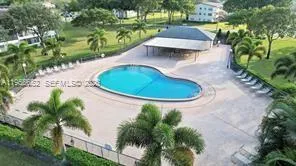 a view of a tennis ground with large trees