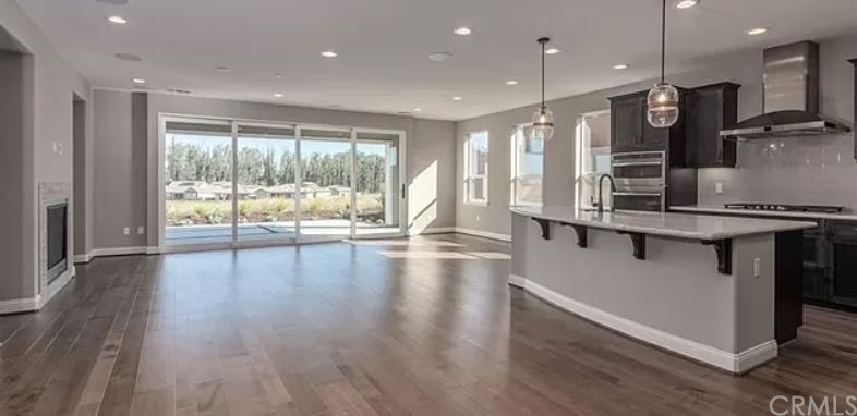 1555 Eucalyptus Road Nipomo, CA 93444 - Photo 2 of 5 a kitchen with stainless steel appliances granite countertop a stove top oven a sink with wooden cabinets and wooden floor