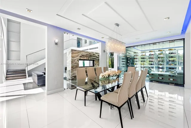 a living room with couches a flat screen tv and a dining table with a large window