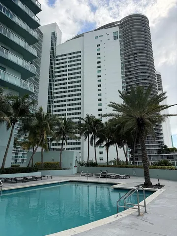 a living room with patio furniture and a floor to ceiling window