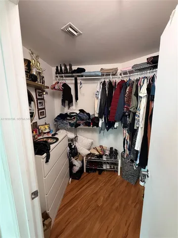 a view of walk in closet with clothes and shoes