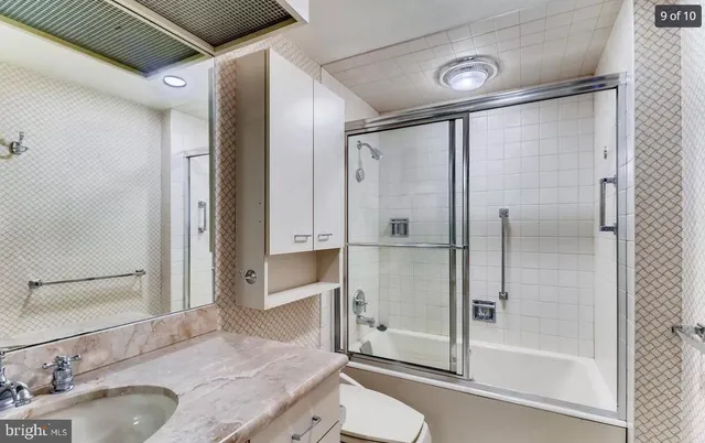 a bathroom with a granite countertop sink mirror and shower