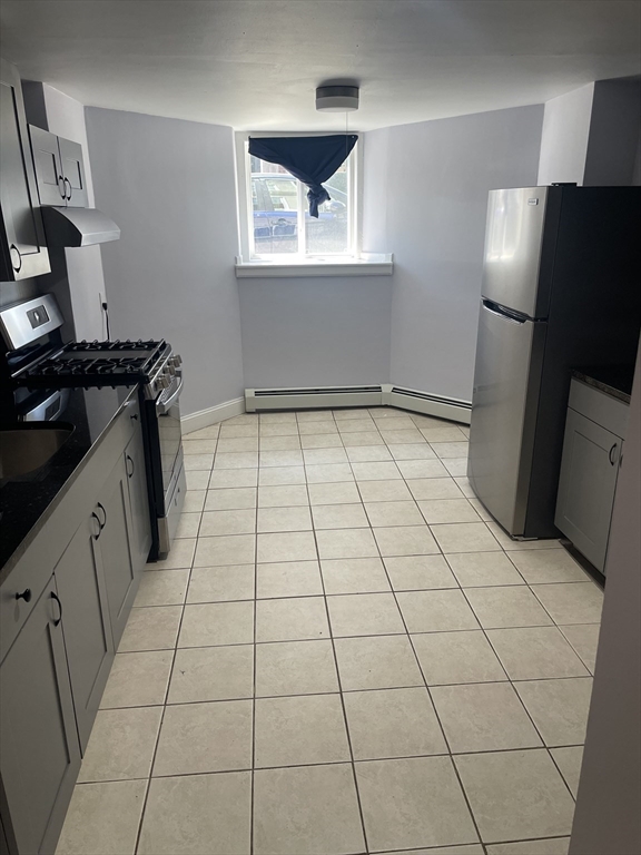 23 Spring Street, Unit B Malden, MA 02148 - Photo 7 of 9 a view of a refrigerator in kitchen and an empty room