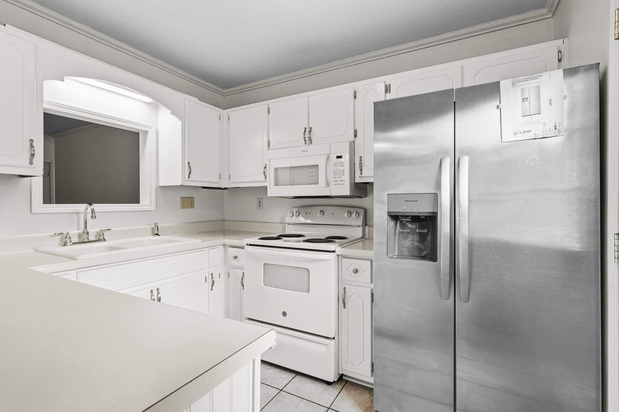 207 Pinoak Court Crestview, FL 32539 - Photo 9 of 33 a kitchen with white cabinets and stainless steel appliances